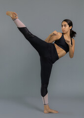 Joven mujer latina mexicana atleta entrenando artes marciales: taekwondo, karate, box. Vestida de...