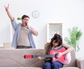 Young family singing and playing music at home