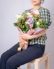 The woman is holding a bouquet.