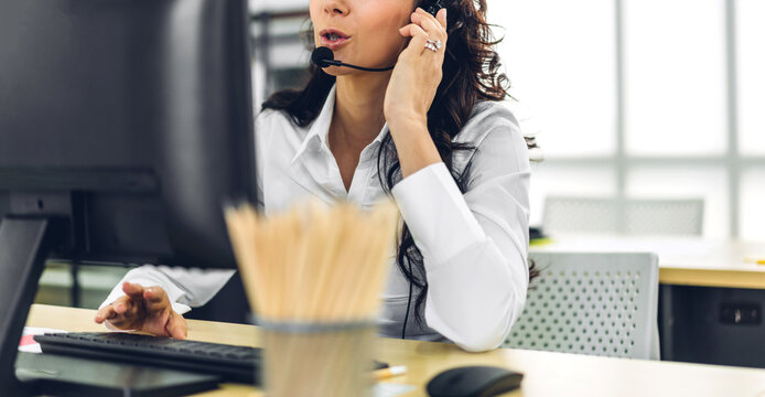 Beautiful happy call center smiling businesswoman operator customer support consult phone services agen working with wireless headset microphone and computer at call center office