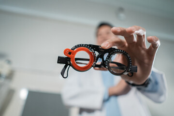 a trial frame is being held by a doctor at an eye clinic against the background of the clinic's...