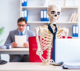Businessman working with skeleton in office