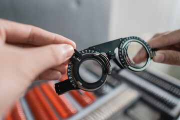 an adjustable axis trial frame is being held by a doctor in an eye clinic with a doctor background...