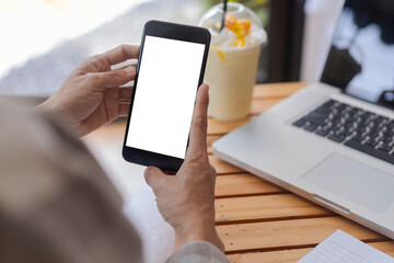 Top view female hands holding smart phone with blank white screen. Women hands workspace, close-up hand holding smartphone blank screen for text and content on wood table background.
