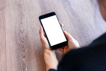 Top view female hands holding smart phone with blank white screen. Women hands workspace, close-up hand holding smartphone blank screen for text and content on wood table background.