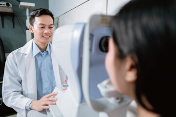 a doctor is examining a female patient using an eye computer at an eye clinic