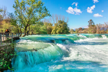 Naklejka premium Beautiful natural landscape of Manavgat waterfall in national park on sunny spring day. Unique azure water color with splashes, Side, Antalya,Turkey