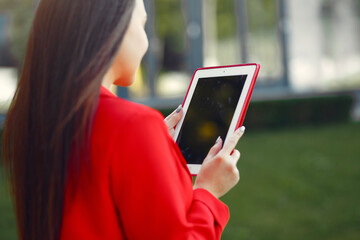 Woman in red jacket use a tablet