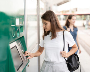 Fototapeta na wymiar Nice woman traveler buying ticket in subway at ticket vending machine. High quality photo