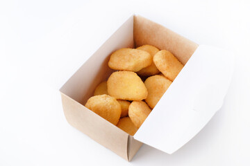 Close-up of home made chicken fried nuggets in paper box for delivery isolated on white