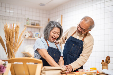 Asian senior couple helping each other for homemade bakery cooking.