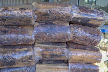 Pile of Shrink wrapped firewood on display at a supermarket