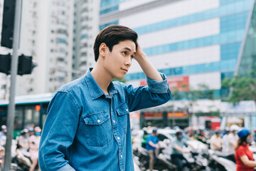 Image of young Asian man walking on the street
