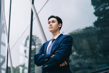 Image of Young asian businessman with glass building background