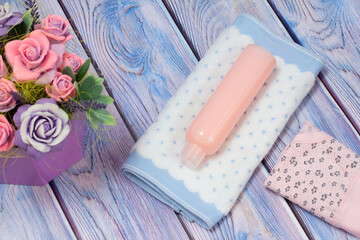 Towel, shampoo and women panties on a wooden background.