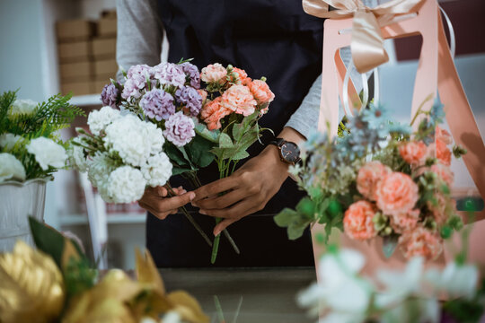 portrait florist preparing a gift flower on table workspace for customer