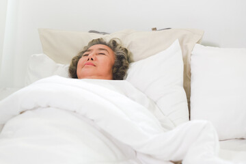 Asian Elderly woman sleep and sweet dream on bed.
