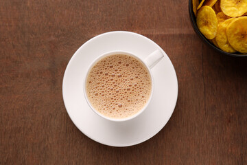 Top view of Indian Chai or traditional beverage milk tea and spices Kerala India. Cup of organic ayurvedic or herbal drink India, good in winter for immunity boosting.