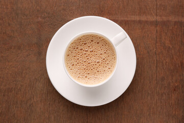 Top view of Indian Chai or traditional beverage milk tea and spices Kerala India. Cup of organic ayurvedic or herbal drink India, good in winter for immunity boosting.