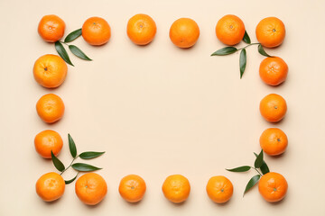 Frame made of sweet tangerines and leaves on color background