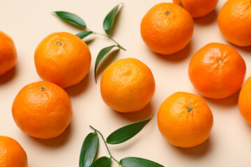Composition with sweet tangerines and leaves on color background, closeup