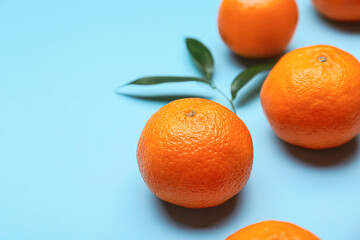 Composition with sweet tangerines and leaves on color background, closeup