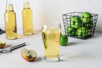 Glass of cold apple cider on table