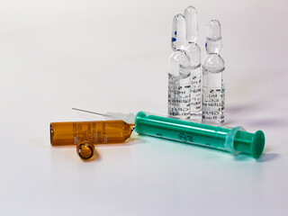 a syringe and ampules on white background