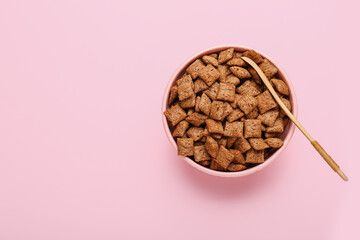 Bowl with tasty corn pillows on color background