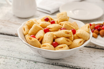 Bowl with tasty corn pillows on white wooden background