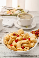 Bowl with tasty corn pillows on white wooden background