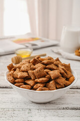 Bowl with tasty corn pillows on white wooden background