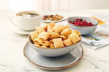 Bowl with tasty corn pillows on light background