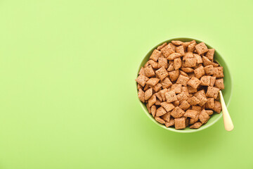 Bowl with tasty corn pillows on color background