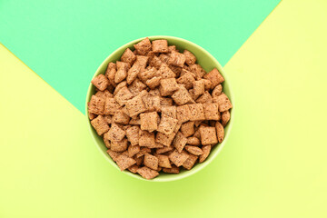 Bowl with tasty corn pillows on color background