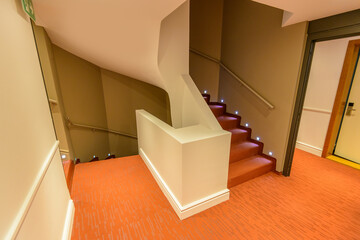 Staircase painted in red. Abstract fragment of the architecture of modern lobby, hallway of the luxury hotel, shopping mall, business center in Lucerne, Switzerland. Interior design.