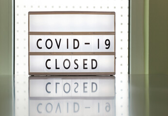 COVID-19 Closed, prevention message on white sign. Government mandatory shutdown order of restaurants, non essential stores or curfew forcing closure of businesses leading to unemployment. Coronavirus