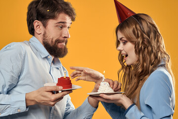 man and woman in festive caps birthday series yellow background