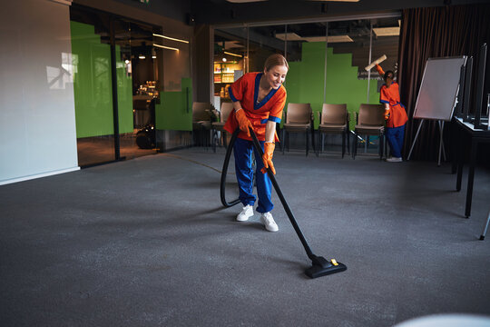 Janitorial staff using a microfiber scrubber and a vacuum cleaner