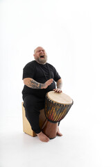 fat funny caucasian bearded man withh tattoes and drum