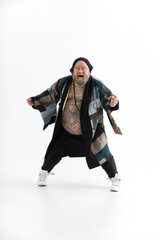 Fat stylish bearded tattoed caucasian man with big belly is posing and dancing wearing ethnic kimono