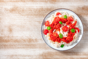 Konjac pasta with tomatoes and basil, shot from above with a place for text