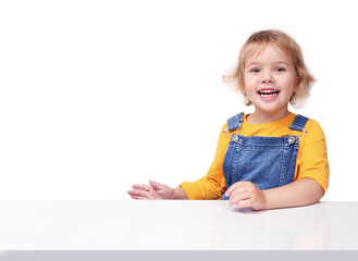 Little child sitting at white table empty copy space background.