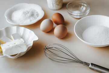 Baking ingredients on beige background. Mockup for recipe or cooking blog with eggs, flour, butter...