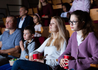 caucasian family sitting at premiere in cinema