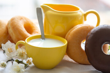 delicious donuts with cup of milk on the table