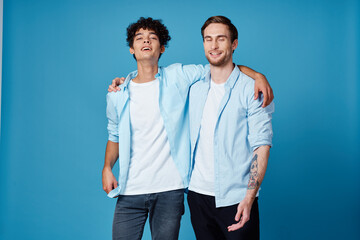 best friends hugging on blue background in matching t-shirts cropped view