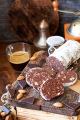 Chocolate salami on a wooden board on a wooden background. Side view.