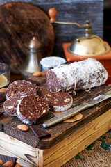 Chocolate salami on a wooden board on a wooden background. Side view.