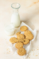 Healthy oatmeal or multigrain cookies with seeds and nuts on baking paper, light concrete background.